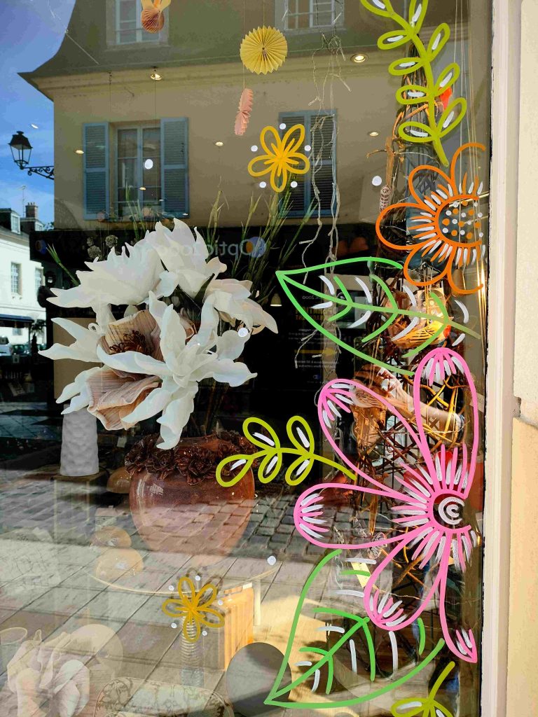 Peinture vitrine représentant de grandes fleurs colorées pour le printemps à Rambouillet dans les Yvelines ou à Paris