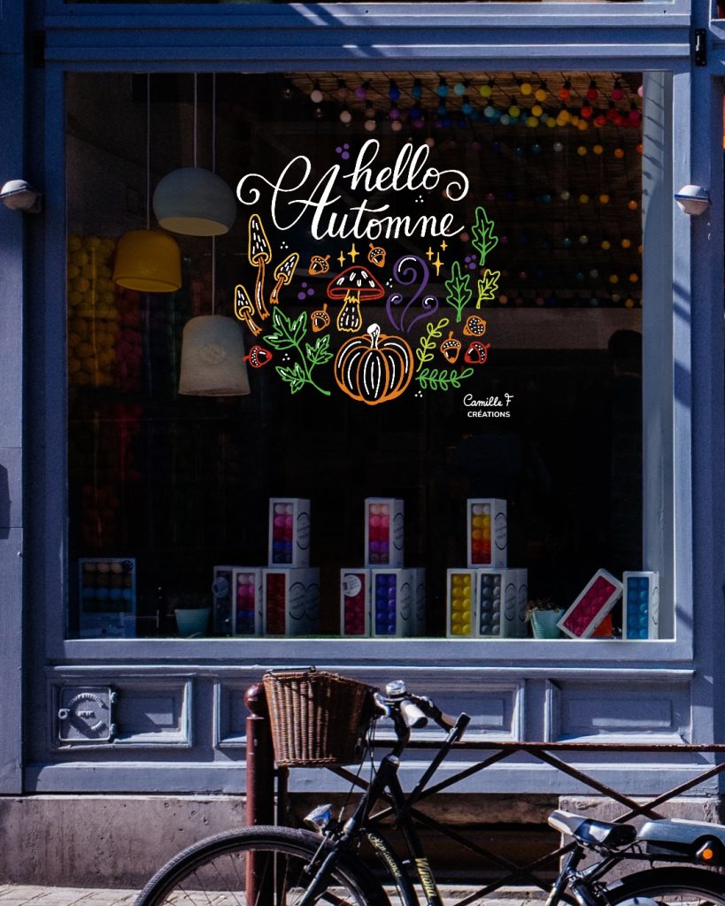 Peinture vitrine sur le thème de l'automne, lettrage "hello automne" avec décor de citrouille, champignons et feuilles