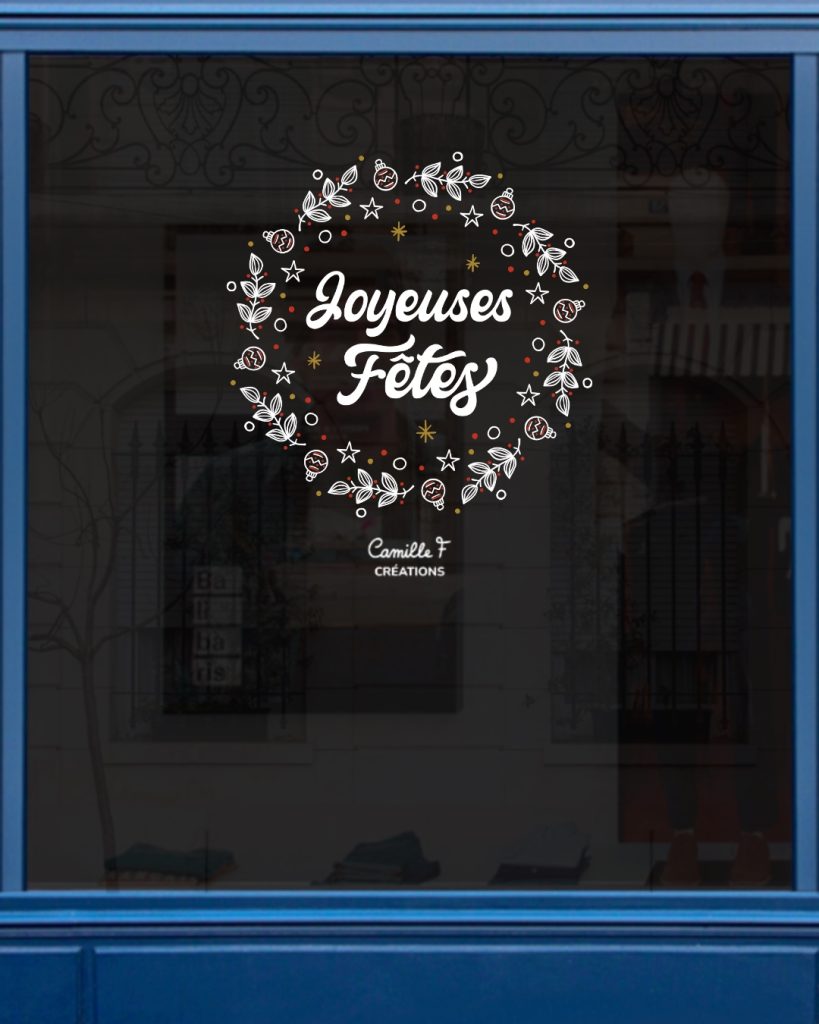 Peinture sur vitrine représentant une couronne de Noël avec l'inscription Joyeuses Fêtes