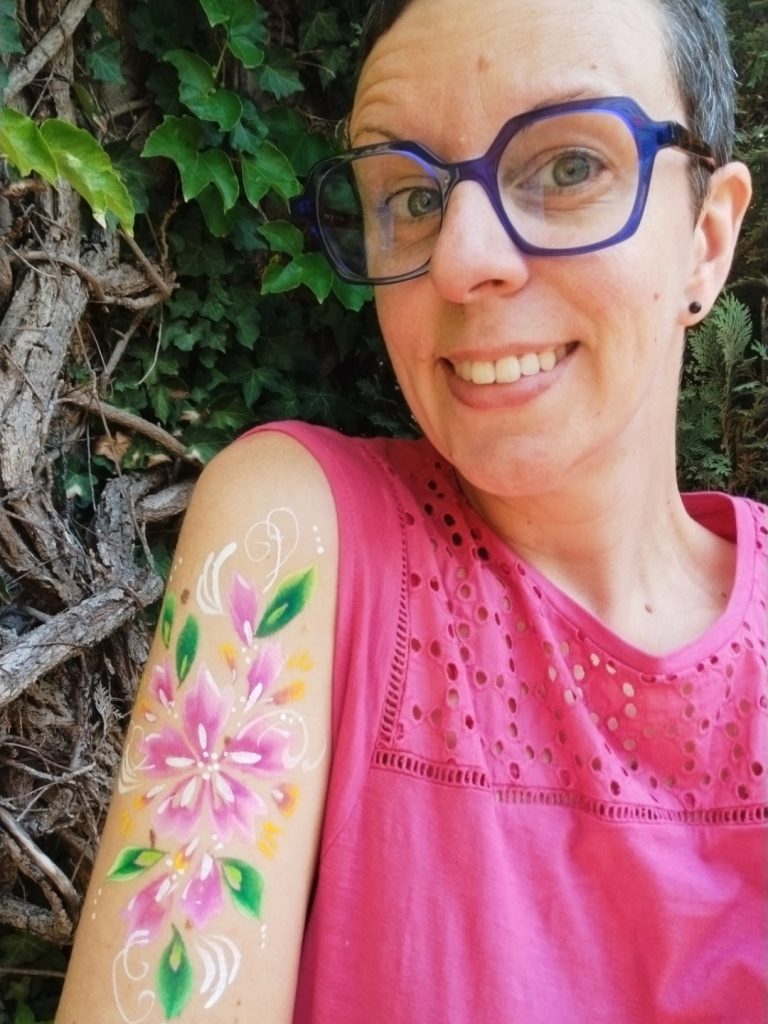 Fleurs roses peintes sur le bras avec la technique du body-painting, par Camille F créations
